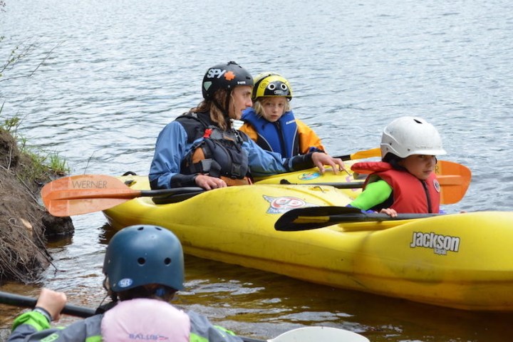 2 kids learning how to kayak