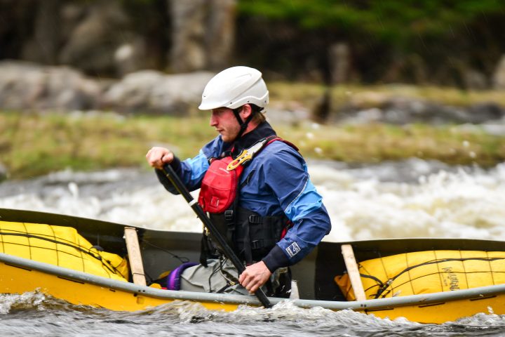 man paddling the river in a kayak