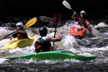 3 kids paddling down whitewater river