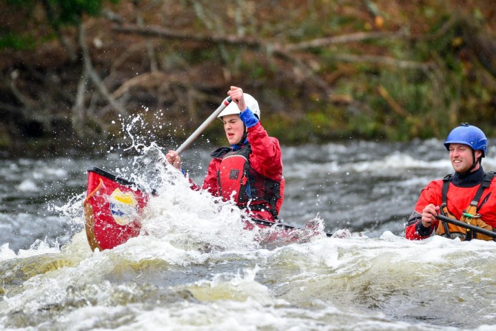 2 men in a canoe going in a river