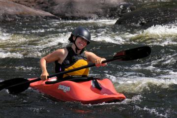 woman in her red kayak paddle down the river