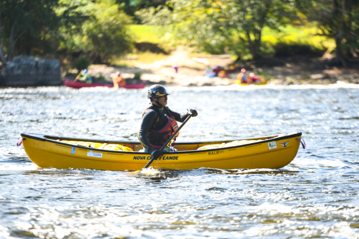 a man riding on the back of a boat in the water