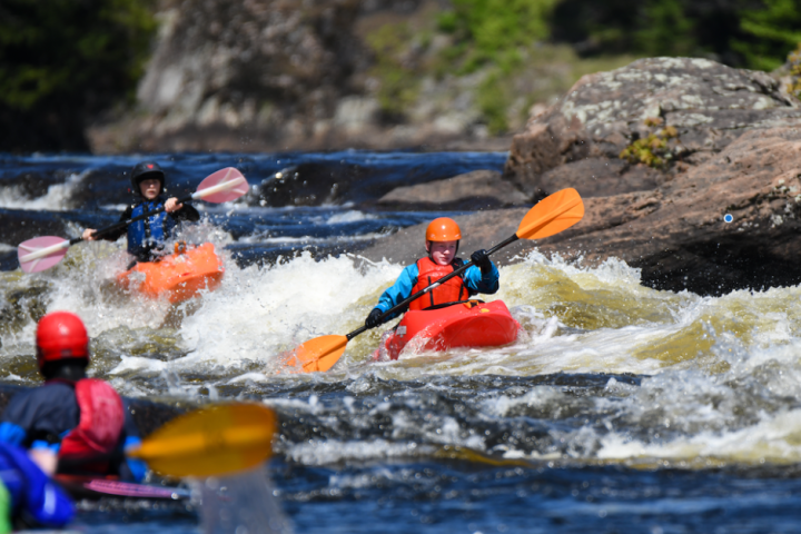 a group of people riding on the back of a boat in the water