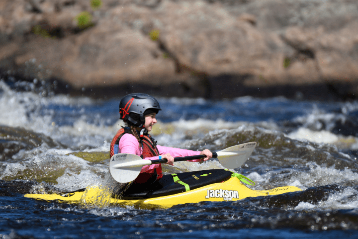 a man riding on the back of a boat in a body of water