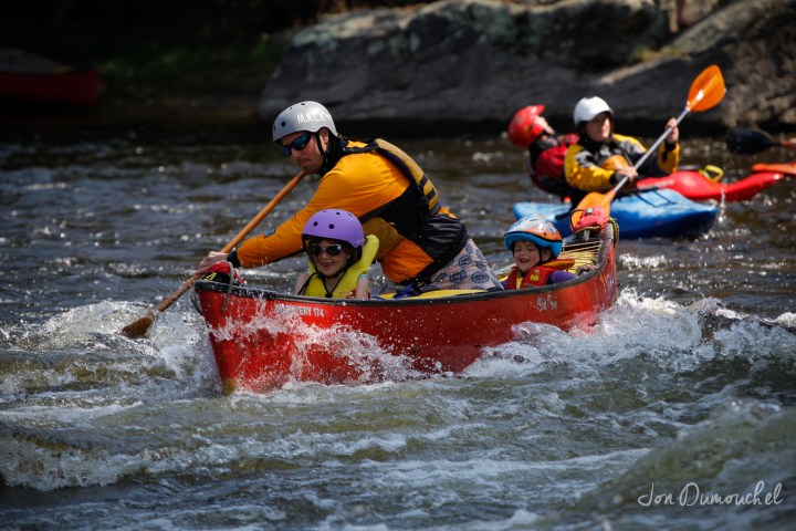 a group of people riding on the back of a boat in the water