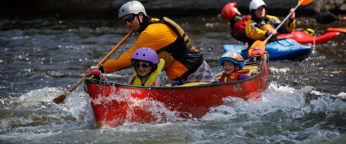 a group of people riding on the back of a boat in the water