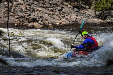 man in single kayak going down whiteriver