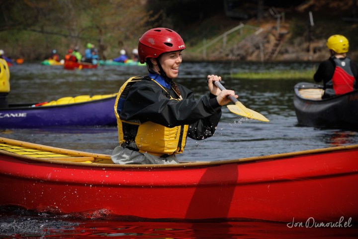 a small boy in a red boat on the water