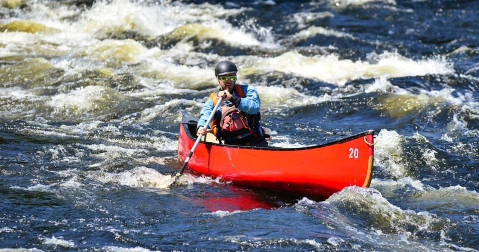 a man riding on the back of a boat in a body of water