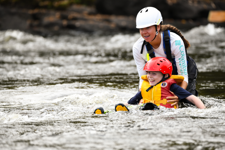 a young boy riding a boogie board in the water