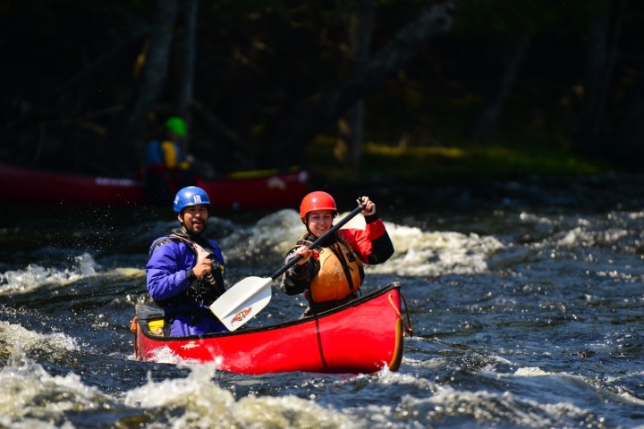 man-and-woman-whitewater-canoeing-down-rapids