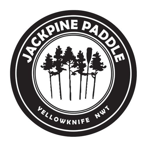 Circular logo with trees and paddle, text: Jackpine Paddle, Yellowknife NWT.