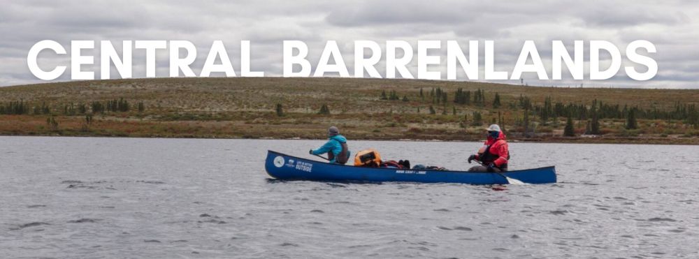 Two people canoeing on a lake with 'Central Barrenlands' text over a hilly landscape.